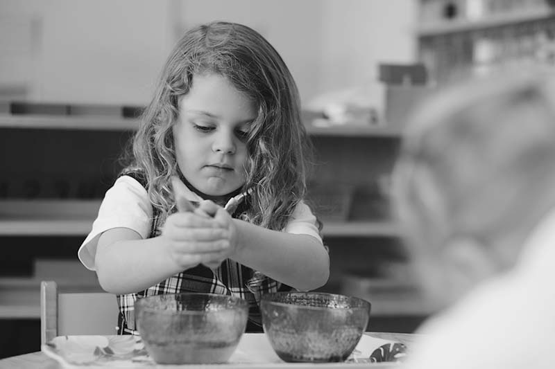 Little girl working in a Bishop Hamilton Montessori classroom