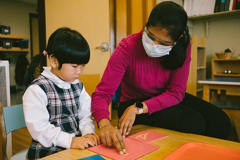 A teacher helping a student with her school work