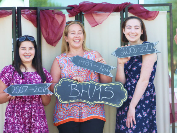 A women and 3 girls holding up BHMS signs